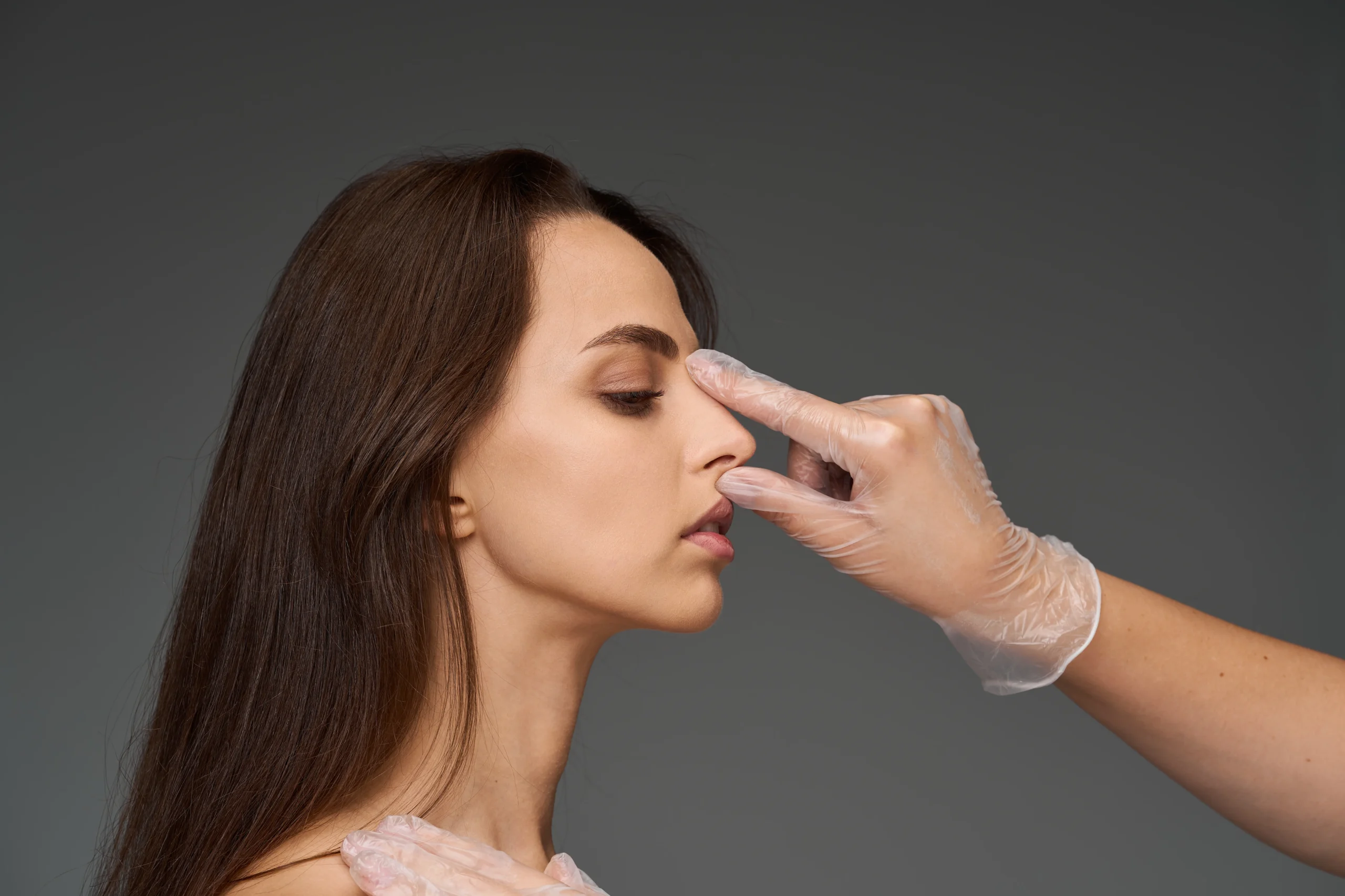 gloved-hand-examining-a-young-woman-s-nose-in-prof-2026-08-14-15-40-38-utc